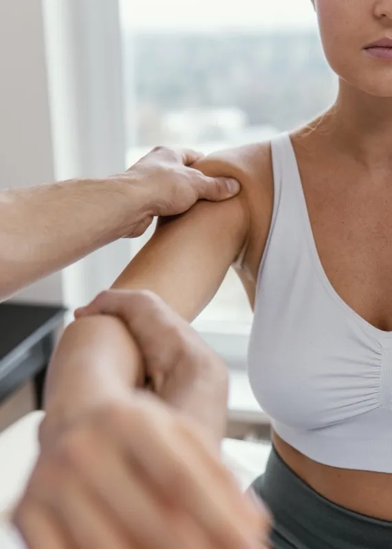 Examen ostéopathique de l'épaule d'une patiente sportive