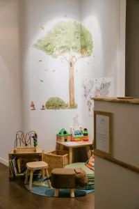 a room with a wall mural and a tree